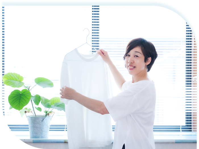 洋服をハンガーに掛ける女性の様子