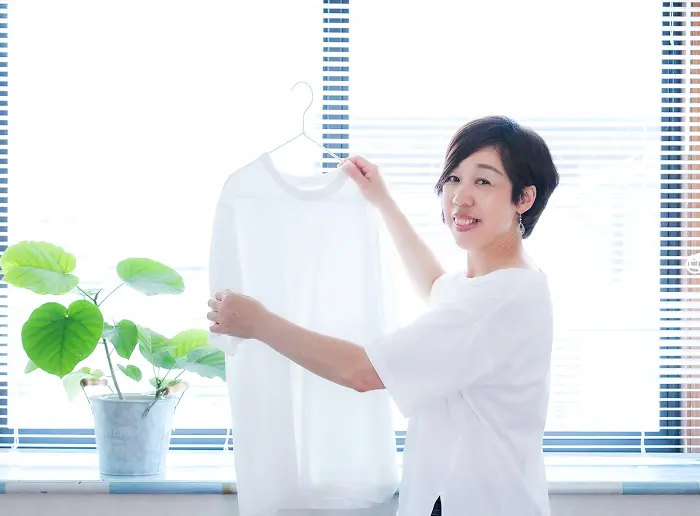 明るい部屋で衣類を整える女性